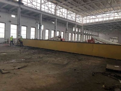 BEAM SITTING ON THE FLOOR WAITING TO BE CUT INTO SECTIONS TO