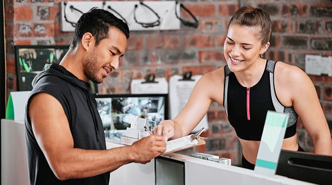 signing up for a gym membership at the front desk 