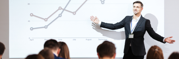 man presenting in front of line graph