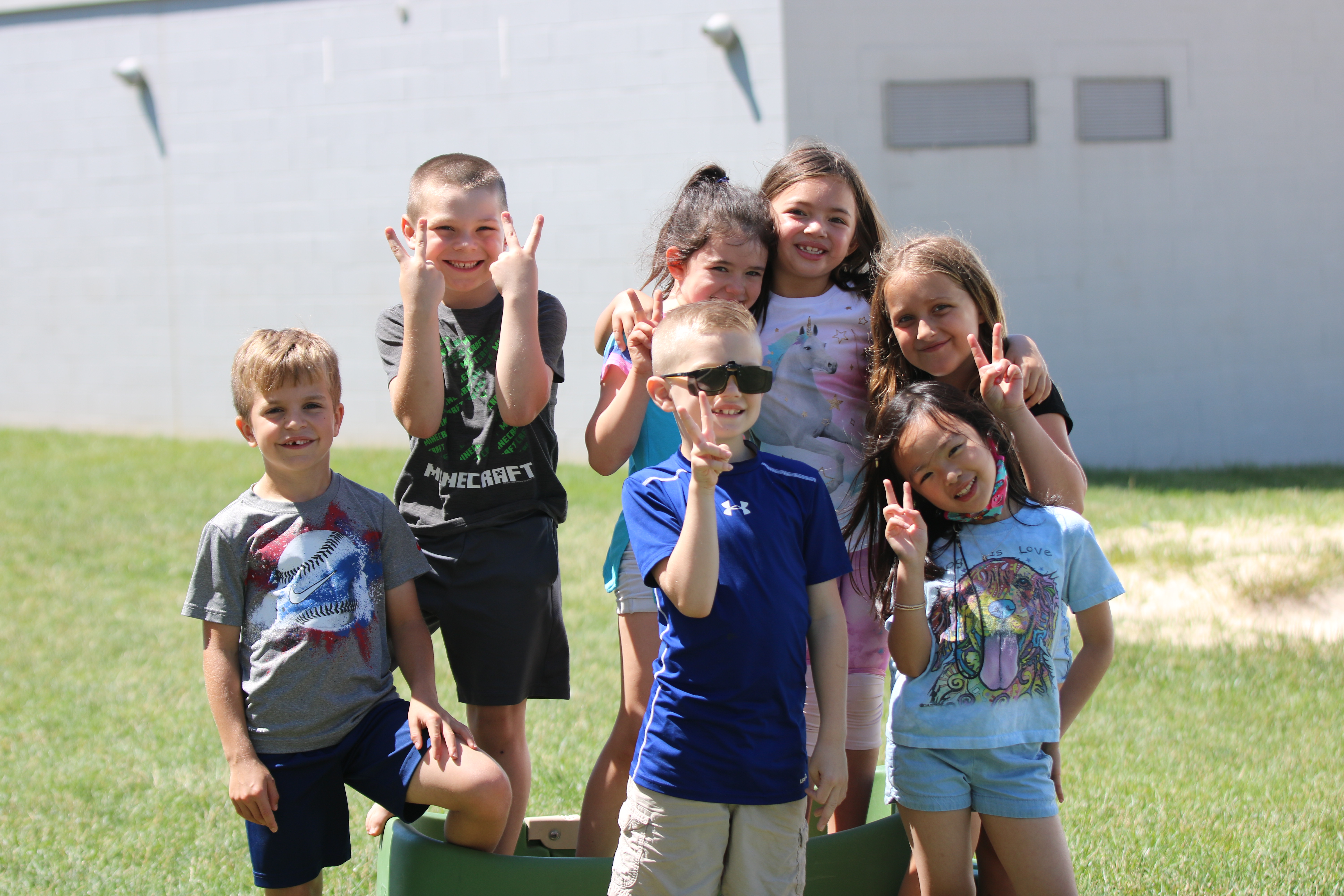 Smiling children holding up peace signs at a summer camp in Hamilton, Ohio