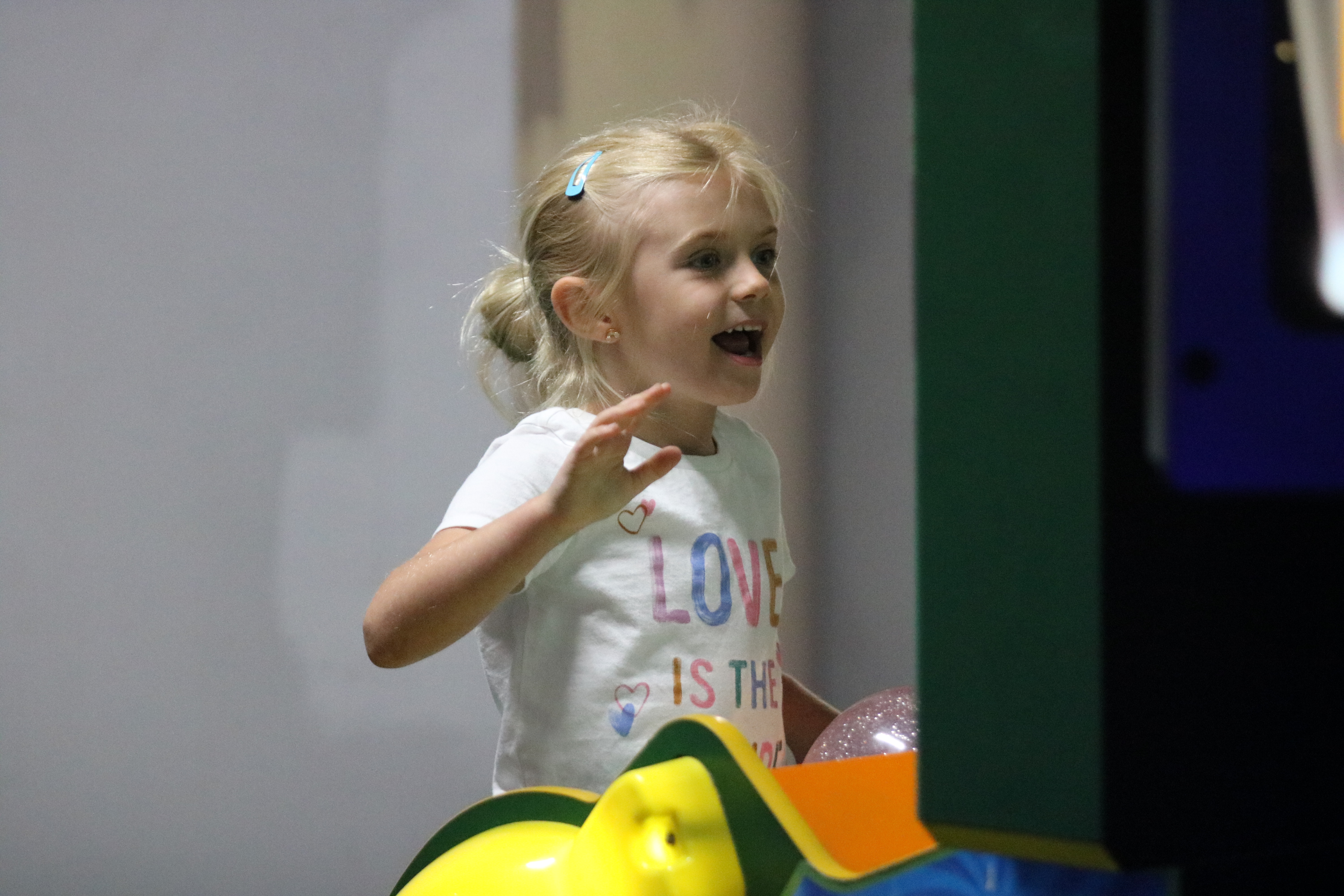 A smiling child looking at the screen of an arcade game at a family-friendly arcade in Hamilton, Ohio