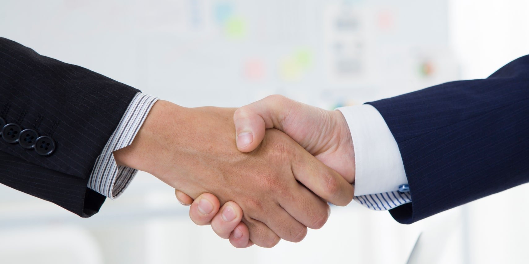 two men in suits shaking hands